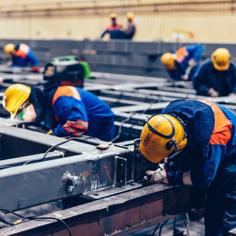 Blue-collar workers at work in a big factory. Heavy industry, labor in shipyard