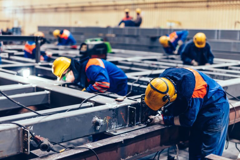 Blue-collar workers at work in a big factory. Heavy industry, labor in shipyard